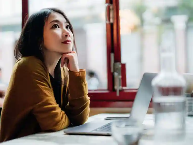 Women over her laptop daydreaming.